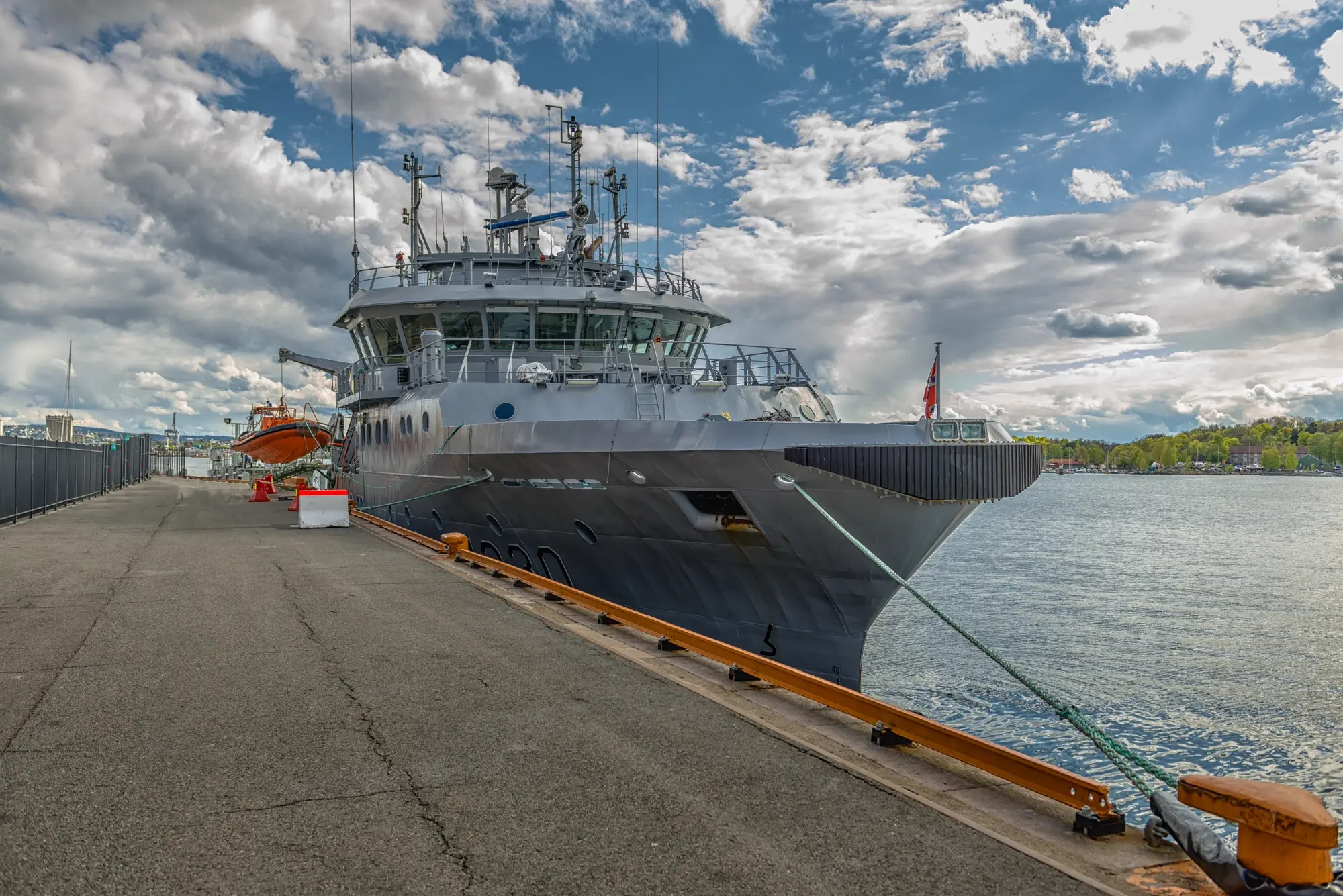 Norwegian naval vessel at quay with the Norwegian flag