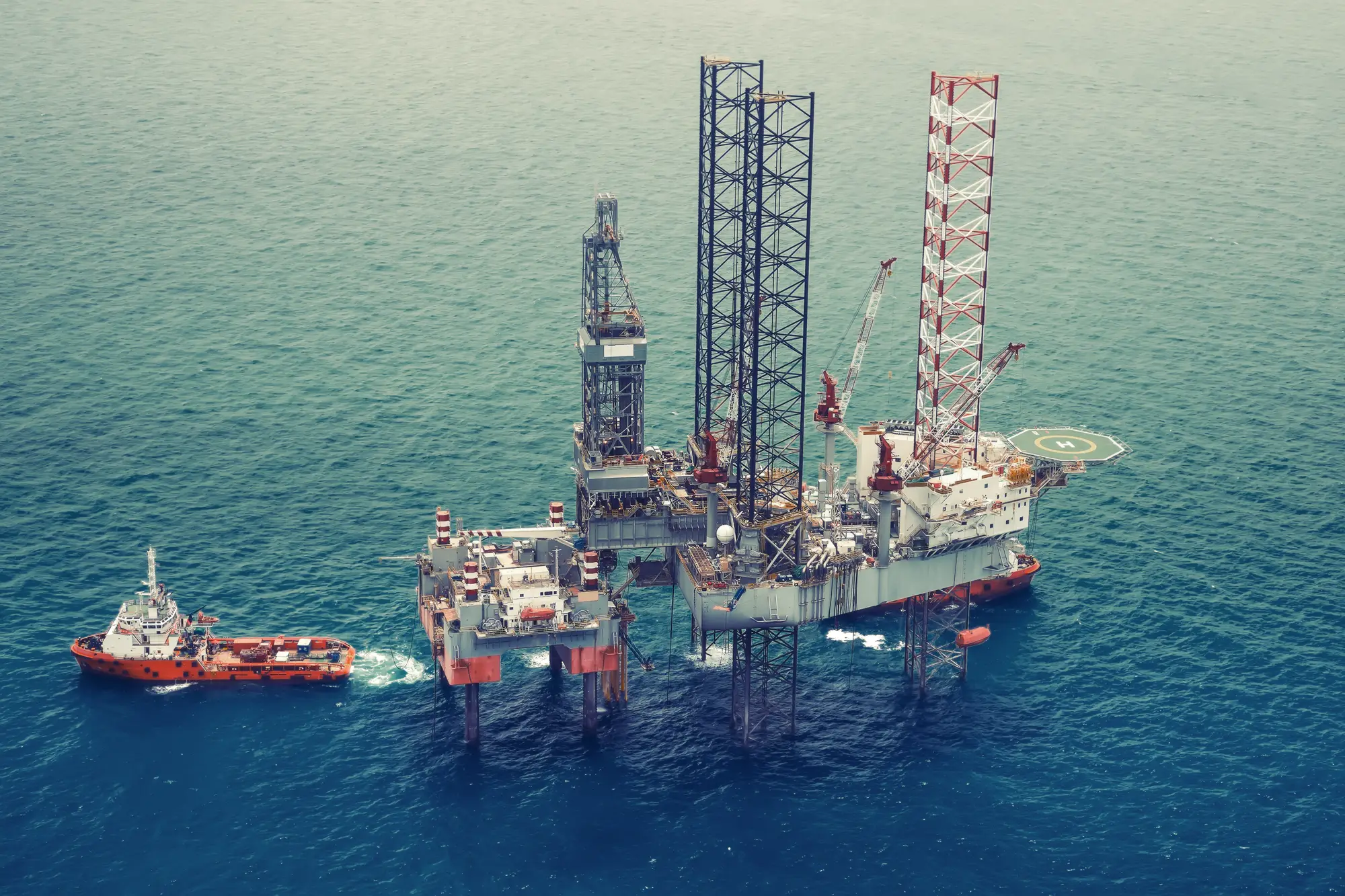 Offshore oil rig with supply vessel on the open sea